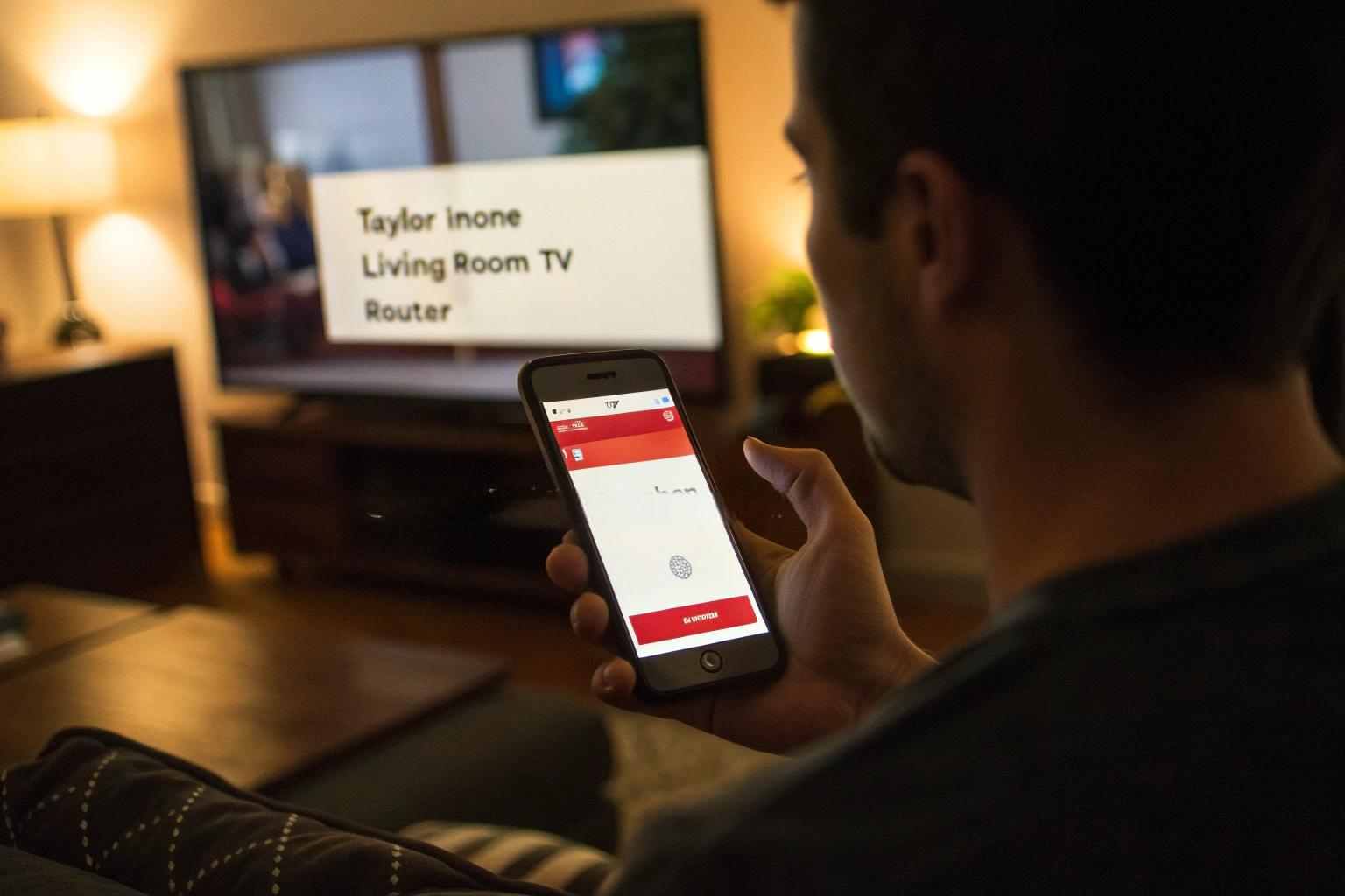 A hand holding a smartphone with a network scanner app showing a suspicious device