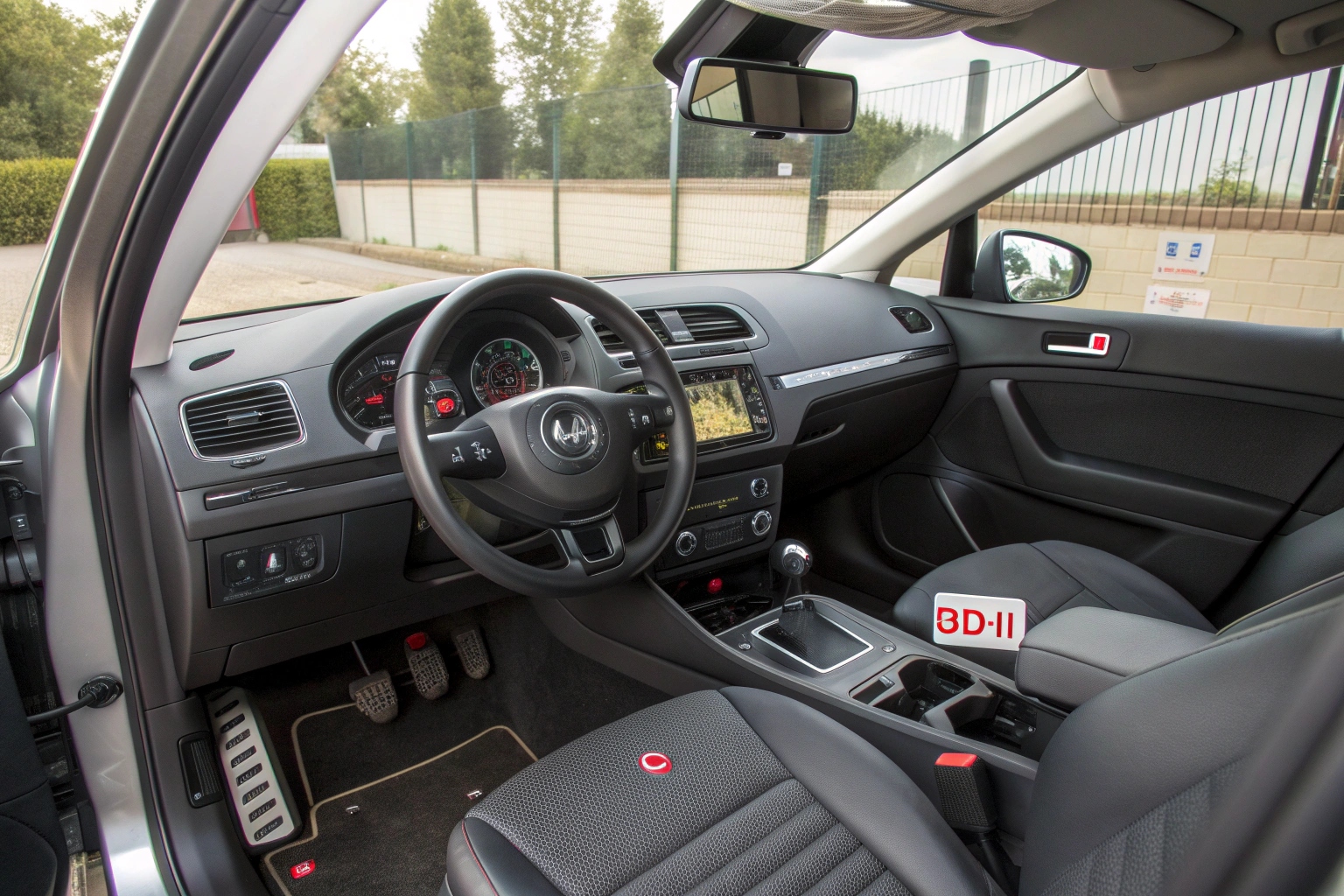 An illustration of a car's interior showing potential hiding spots for cameras and trackers near the rearview mirror, under the dashboard, and in the OBD-II port.