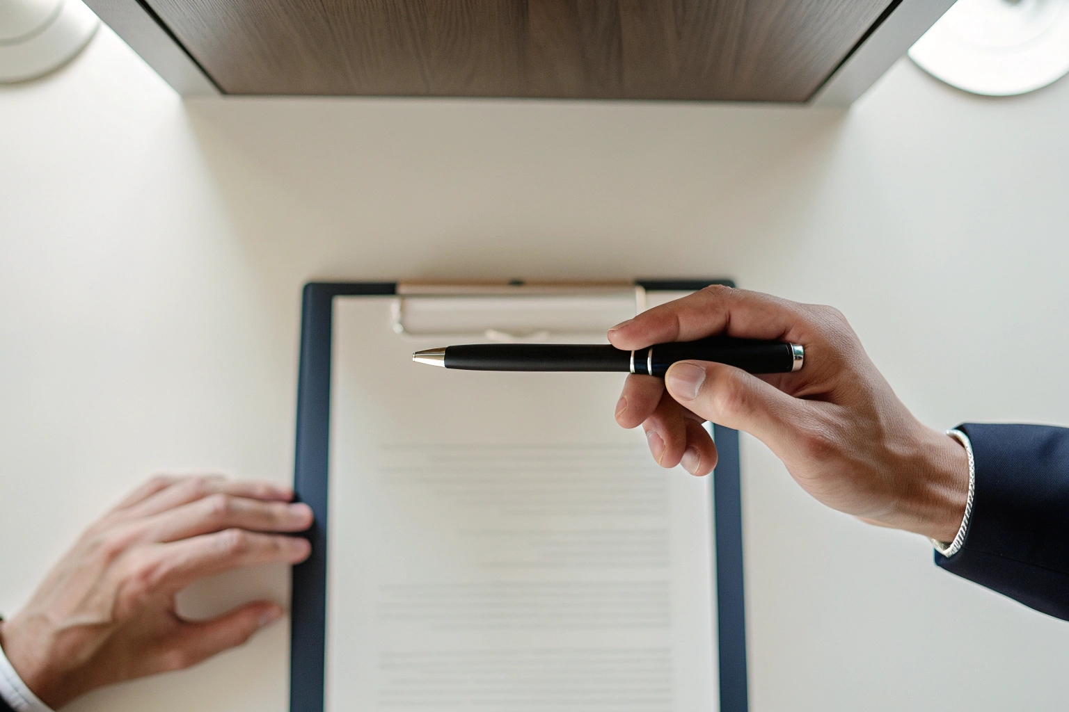 Primo piano di una mano che tiene una penna spia con telecamera mentre firma un documento