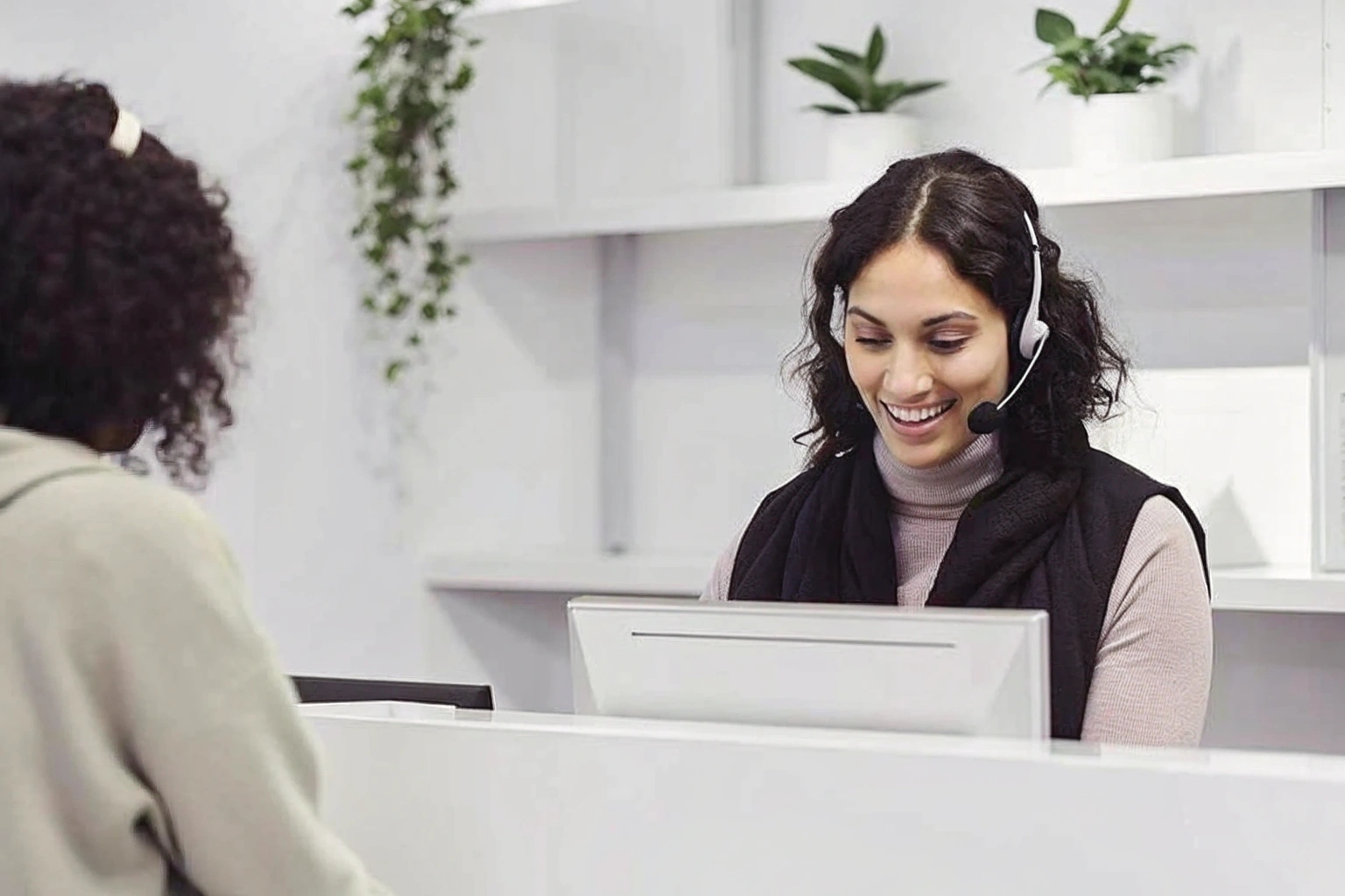 A friendly employee at a retail counter assisting a customer with a smile