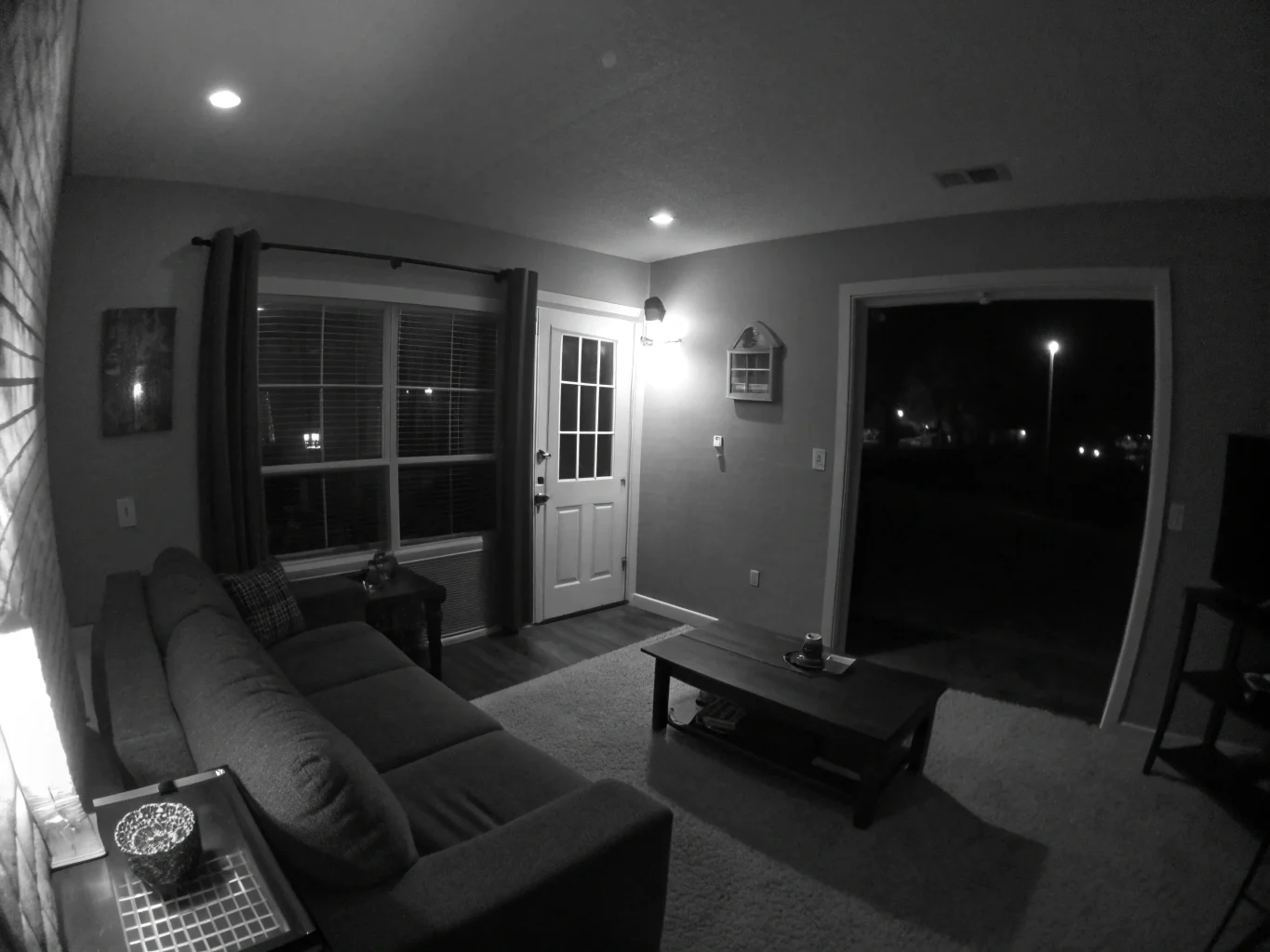 La visione notturna in bianco e nero di una telecamera nascosta di un soggiorno buio