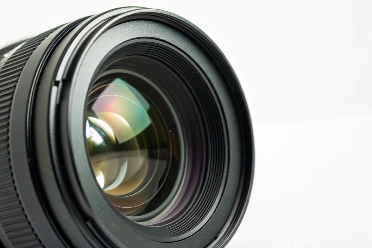 A macro shot of a camera lens showing the glass elements and aperture blades