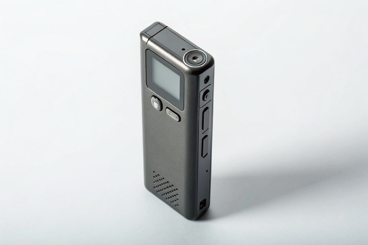 A professional digital voice recorder with a clean design on a simple light grey background.
