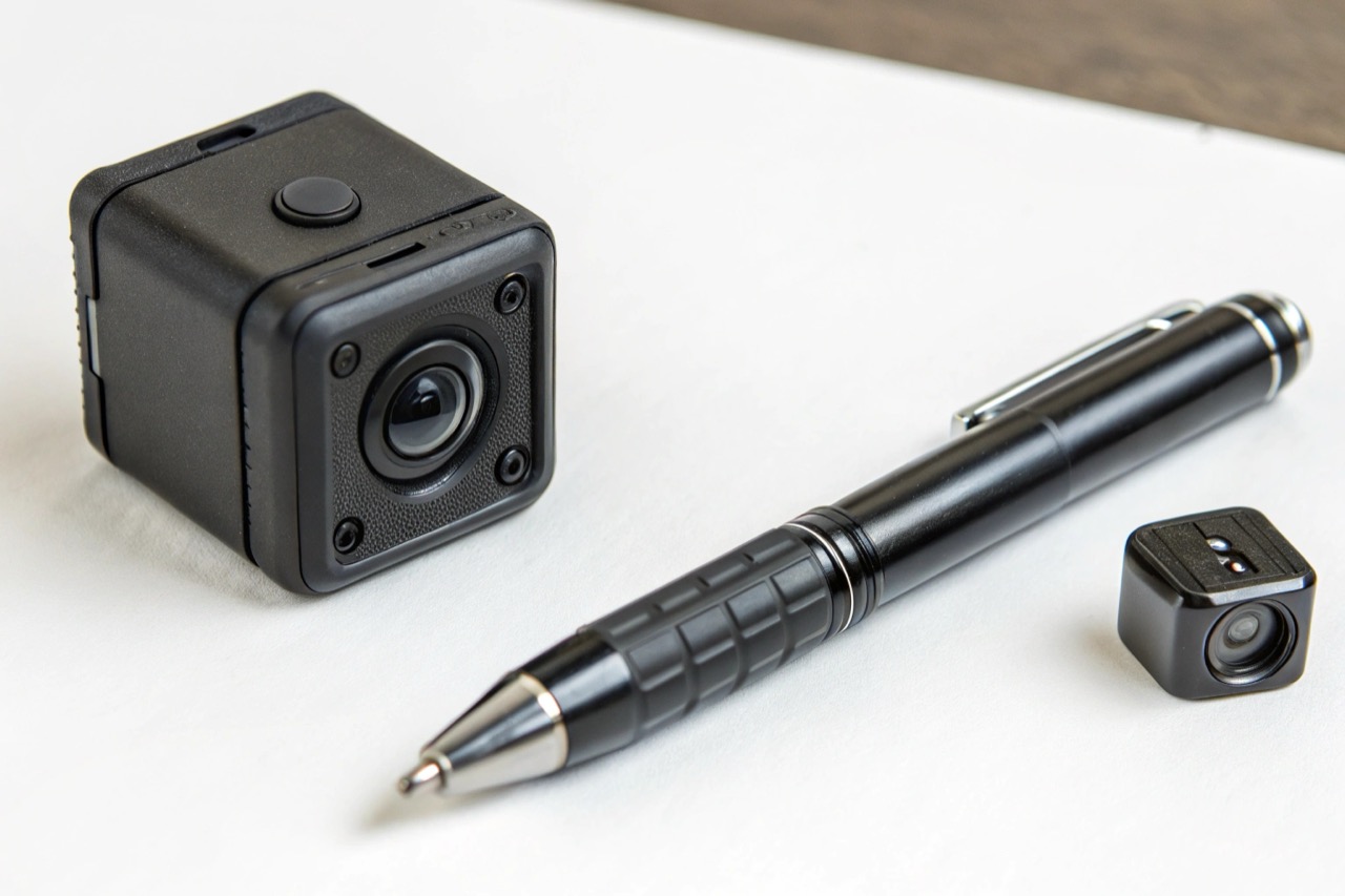 Side by side of a large body cam and a small pen camera